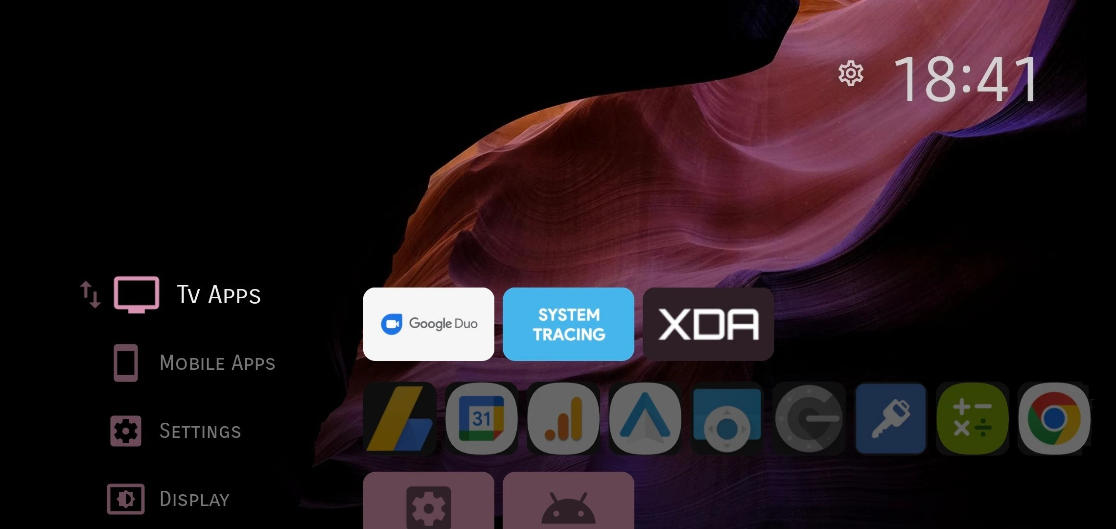 Projectivy Launcher affiche les applications TV et mobiles dans une interface sombre, avec accès rapide aux réglages et aux raccourcis. © Projectivy Launcher
