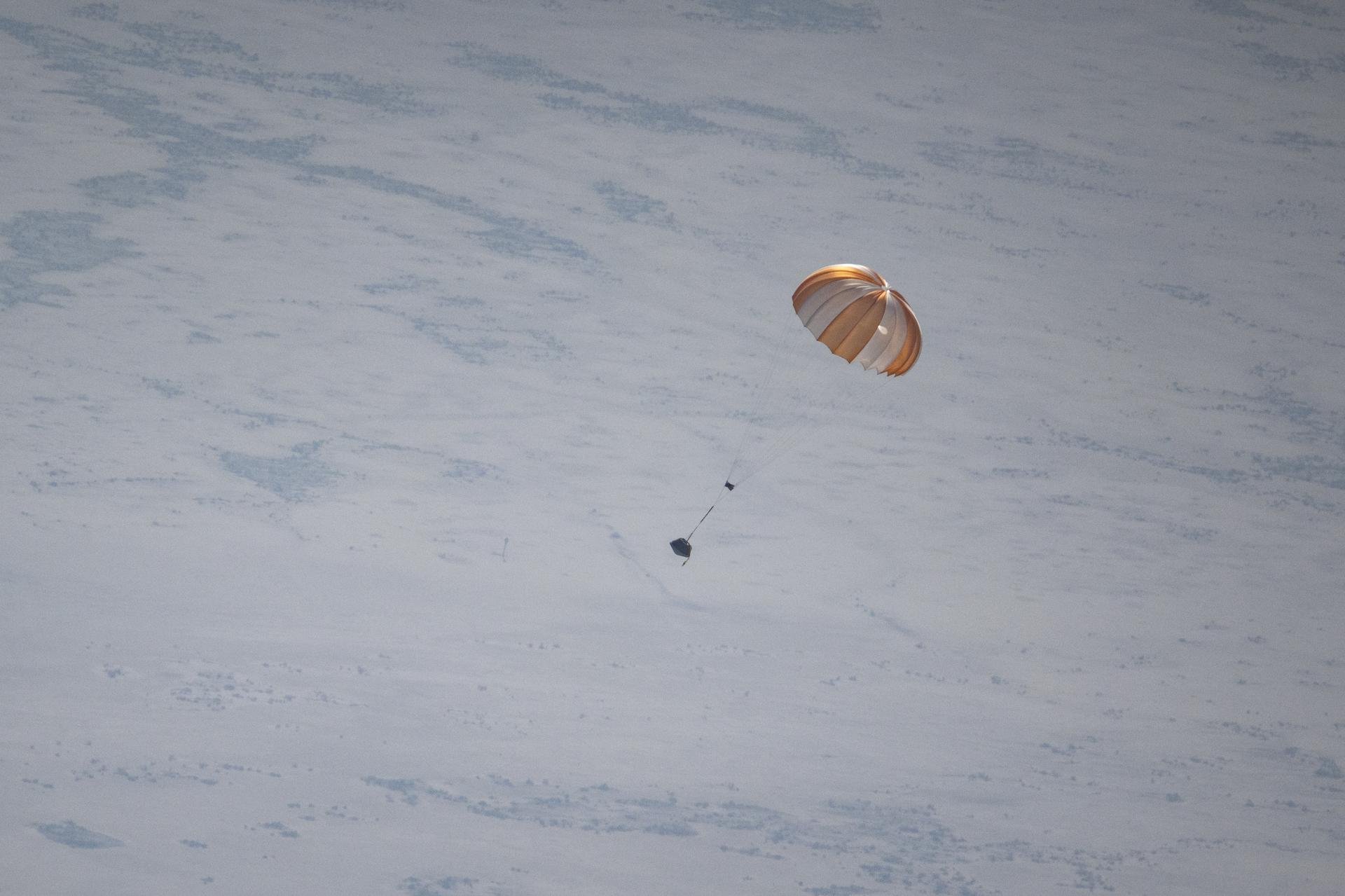 Une fausse capsule lors d'une répétition dans le désert en Utah. On y voit le parachute principal dont l'extraction repose en théorie sur le drogue chute. © NASA