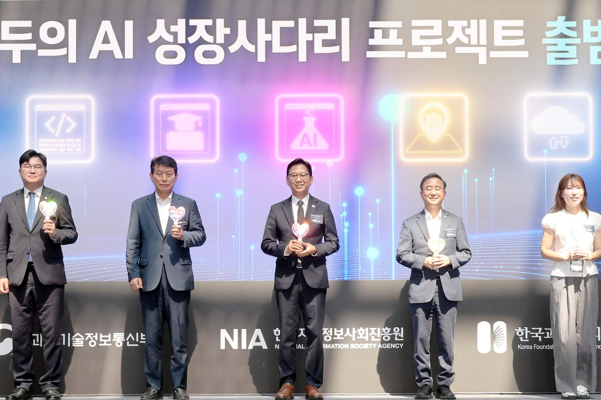 Le vice-Premier ministre et ministre des Sciences et des TIC, Bae Kyung-hoon, au centre, pose avec les participants lors d’une cérémonie consacrée au projet gouvernemental « AI for All », à Gwangju, le 3 août. © Koreatimes