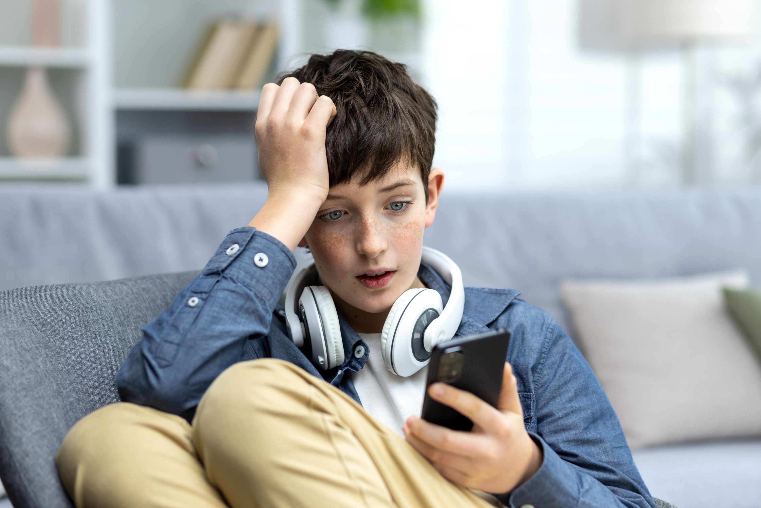 Un adolescent choqué devant son smartphone © Shutterstock.com