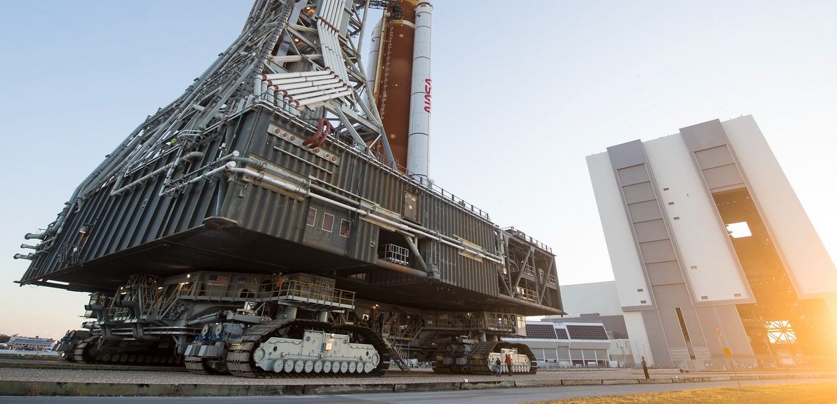 Le « Crawler Transporter 2 » sous la table de lancement est responsable de l'équilibre et du transport avec ses quatre énormes paires de chenilles. Une tâche habituelle, lui qui a transporté les navettes durant 30 ans et même avant... Le même véhicule se chargeait déjà d'Apollo ! Crédits : NASA