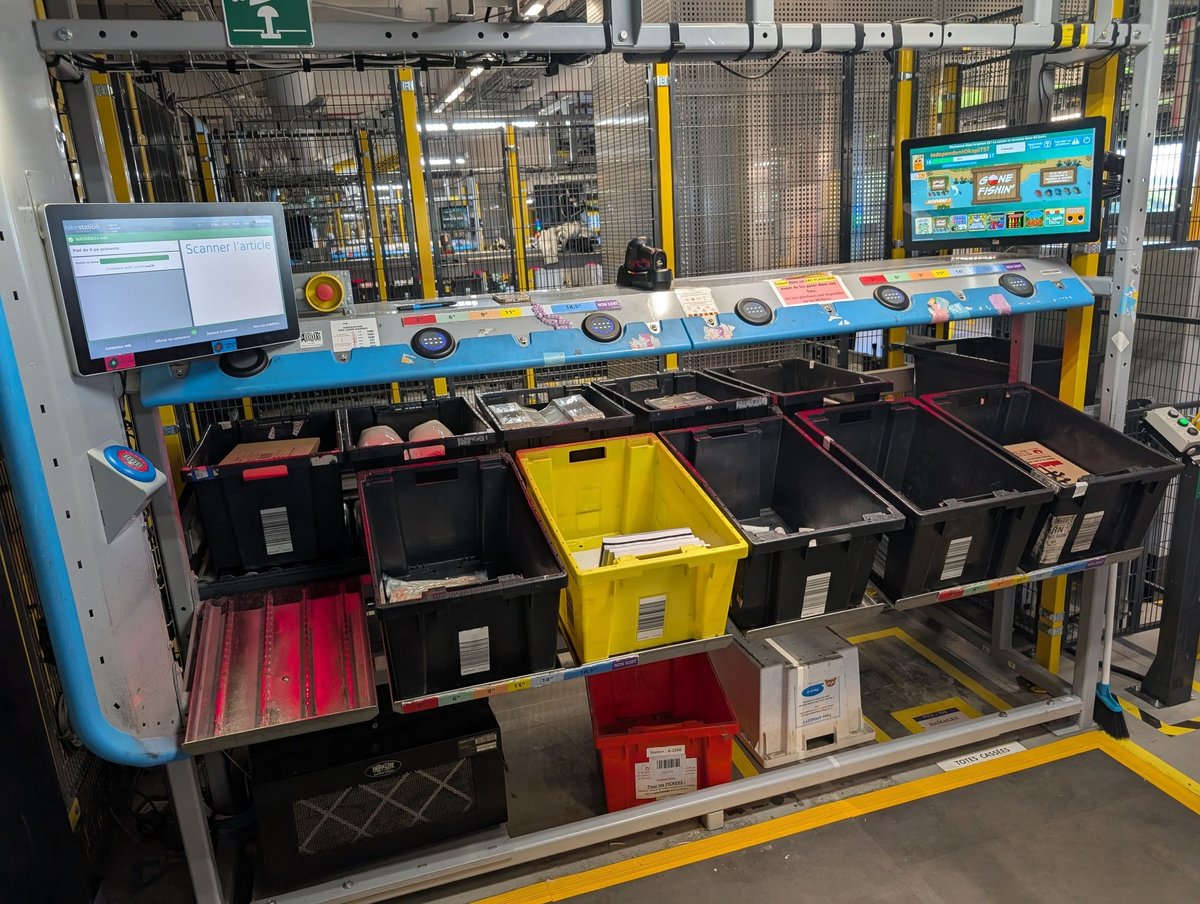 Les produits arrivés dans l'entrepôt grimpent à l'étage pour atterrir ici. Là, ils arrivent dans des bacs noirs et doivent être ensuite dispatchés. Ils peuvent aussi avoir le rôle inverse, celui de déposer à l'intérieur les produits qui seront ensuite expédiés. © Alexandre Boero / Clubic
