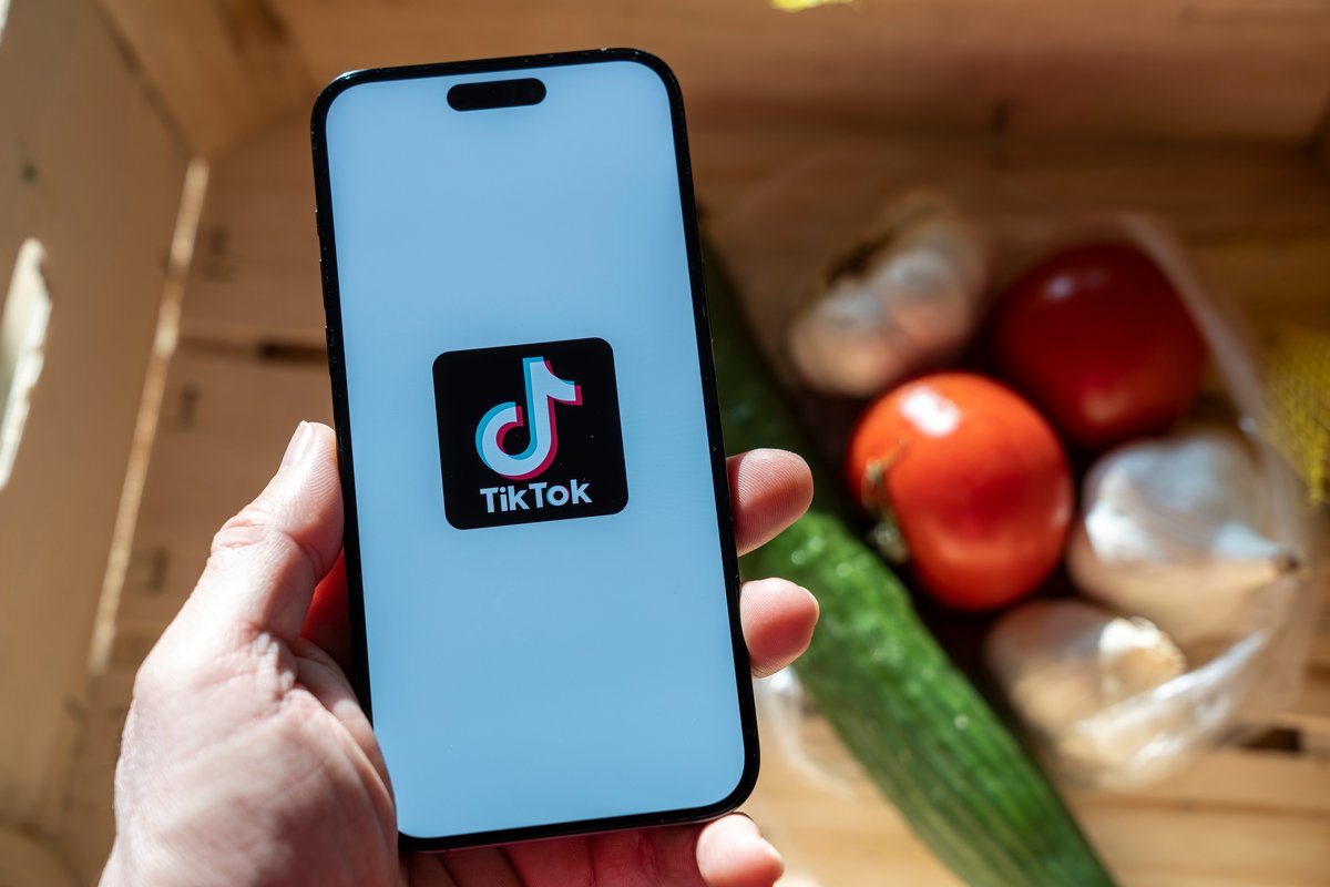 Main tenant un iPhone avec le logo TikTok © Varga Jozsef Zoltan / Shutterstock.com