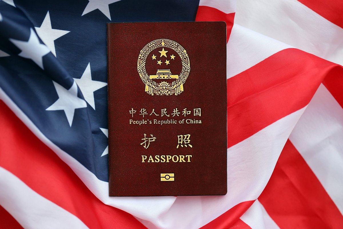 Un passeport chinois, posé sur un drapeau américain, symbole de l'affaire qui embarrasse la justice de l'oncle Sam © Mehaniq / Shutterstock