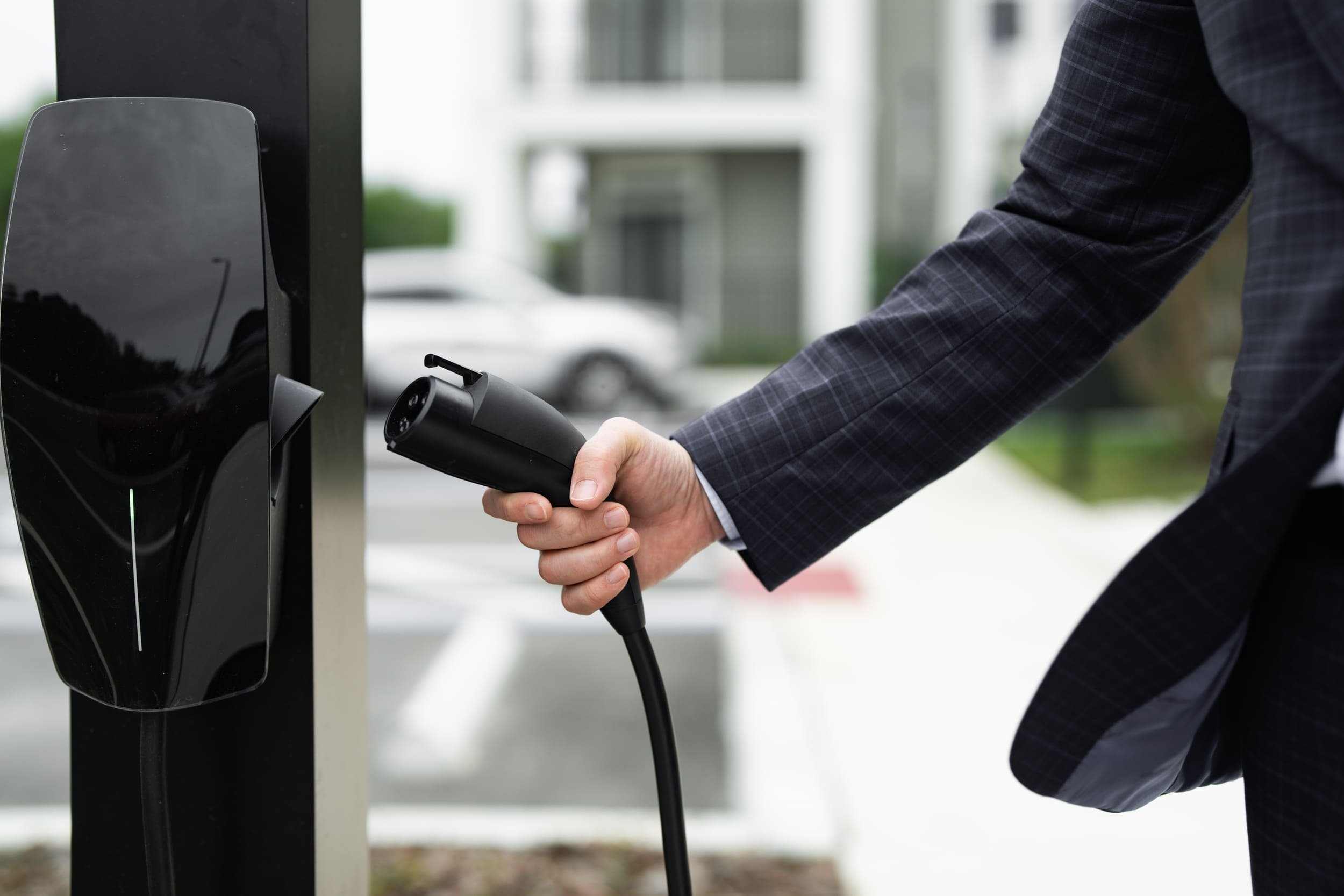 Un homme met sa voiture électrique en charge. ©Volodymyr TVERDOKHLIB / Shutterstock