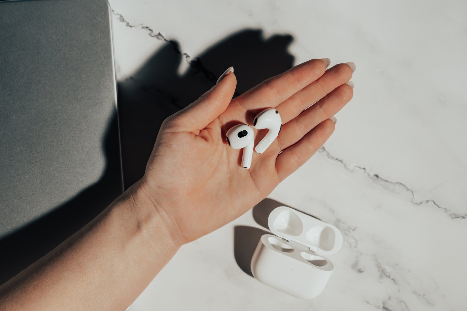 Une femme tient les AirPods 3 dans sa main. ©Stock Holm / Shutterstock