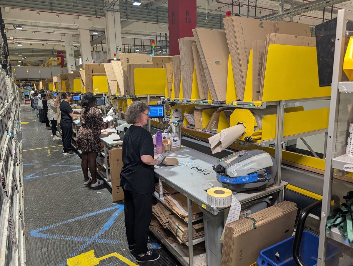 Les salariés d'Amazon emballent leurs colis, et la petite machine à droite va sortir du scotch à la taille adaptée au colis. © Alexandre Boero / Clubic