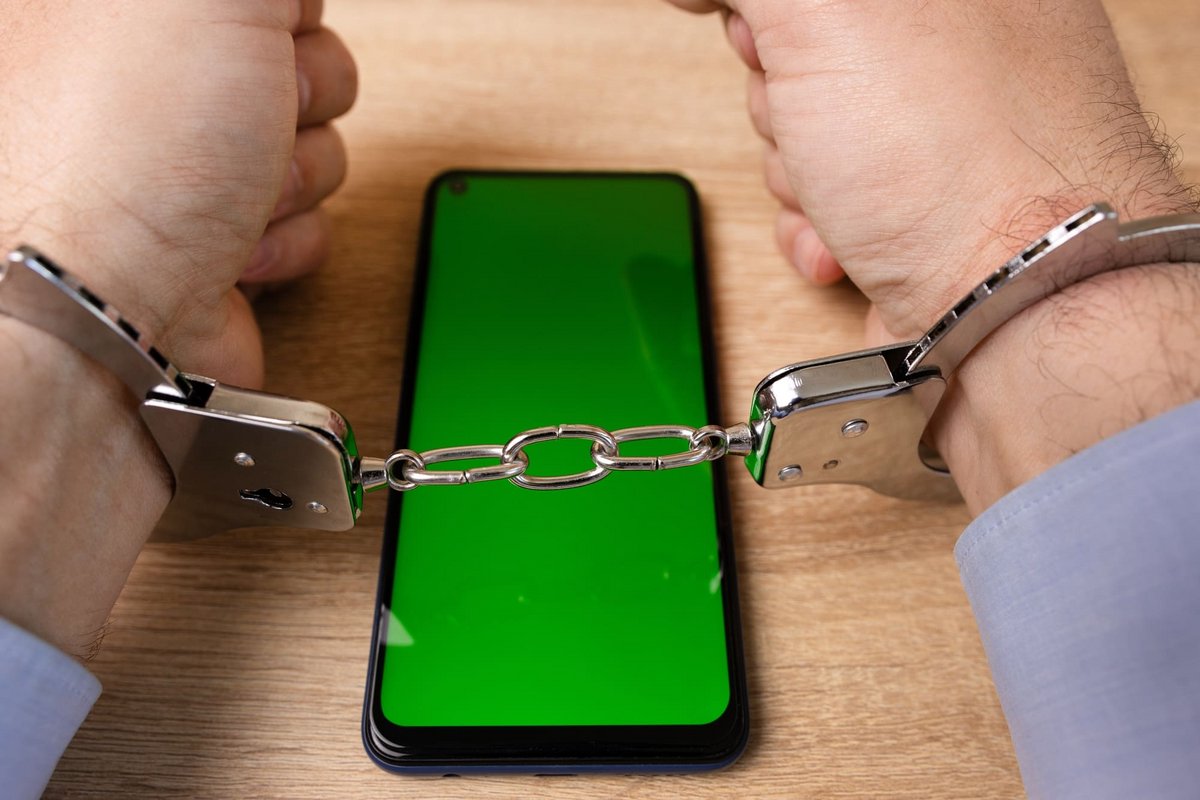 Un homme menotté et un smartphone avec écran vert © Vitstyle / Shutterstock