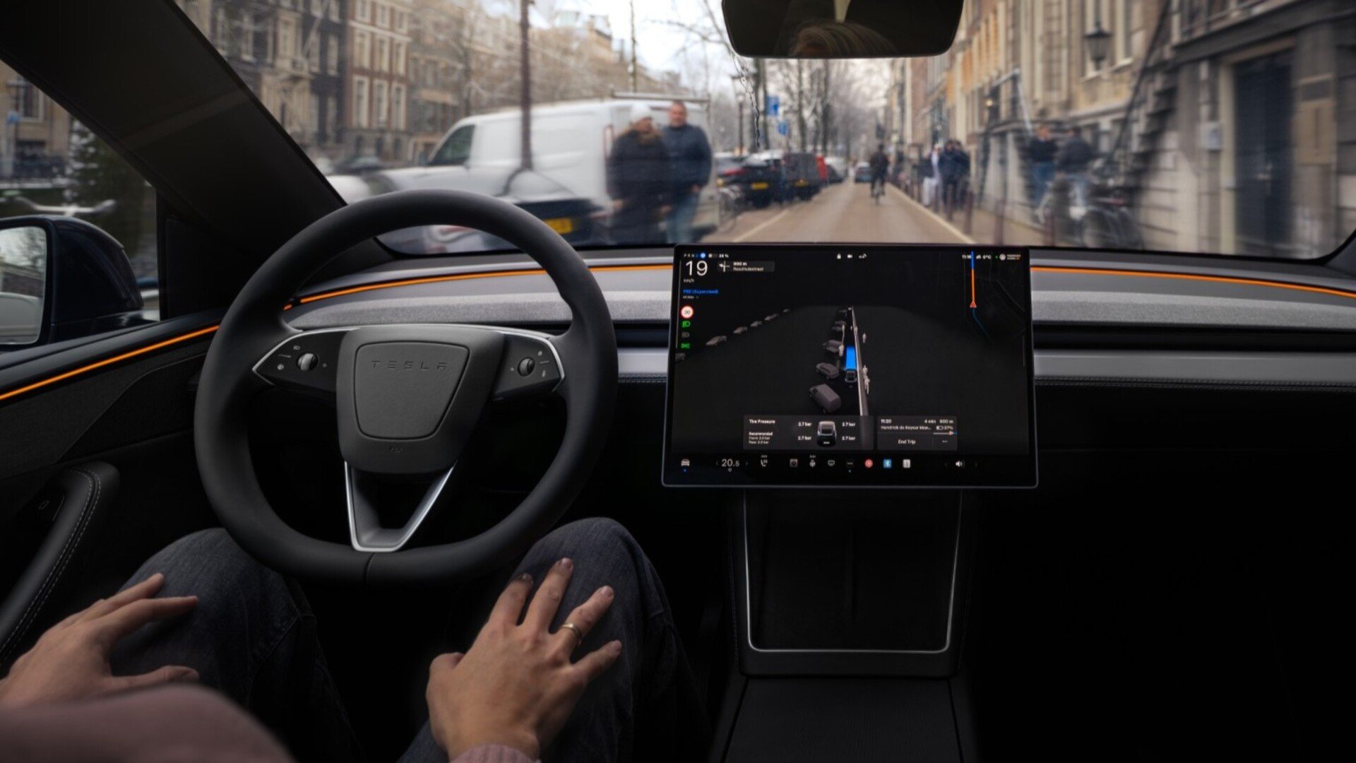 À bord d'une Tesla, le FSD Supervised gère seul la conduite en pleine ville, pendant que le conducteur garde les mains posées sur ses genoux, prêt à reprendre le contrôle à tout moment. © Tesla