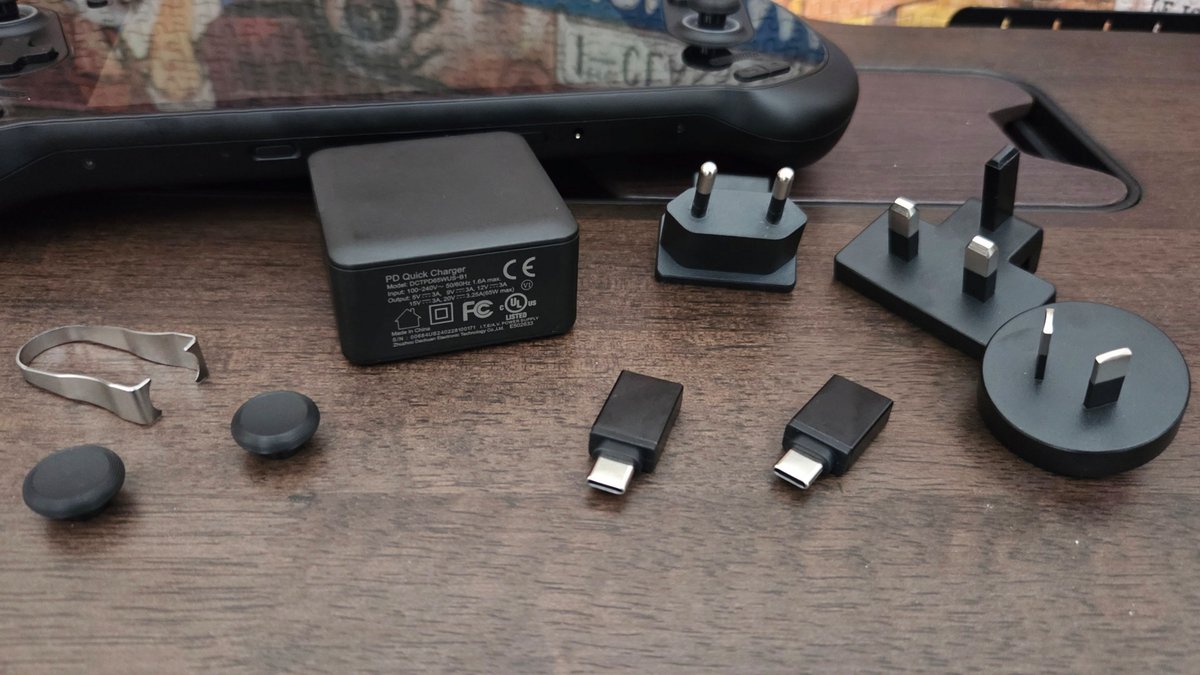 Tous les accessoires livrés avec la console à commencer deux capuchons de stick, quelques adaptateurs USB et d'autres pour le secteur (machine chinoise oblige) : notez la petite brique d'alimentation de 65 watts. ©Nerces pour Clubic
