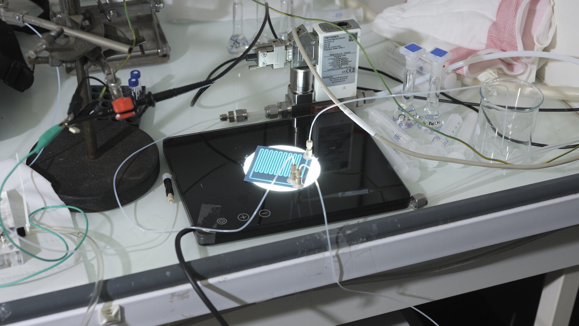 Le microréacteur à plasma de Plaskimia en action, au milieu du matériel de laboratoire nécessaire à son fonctionnement. © Plaskimia