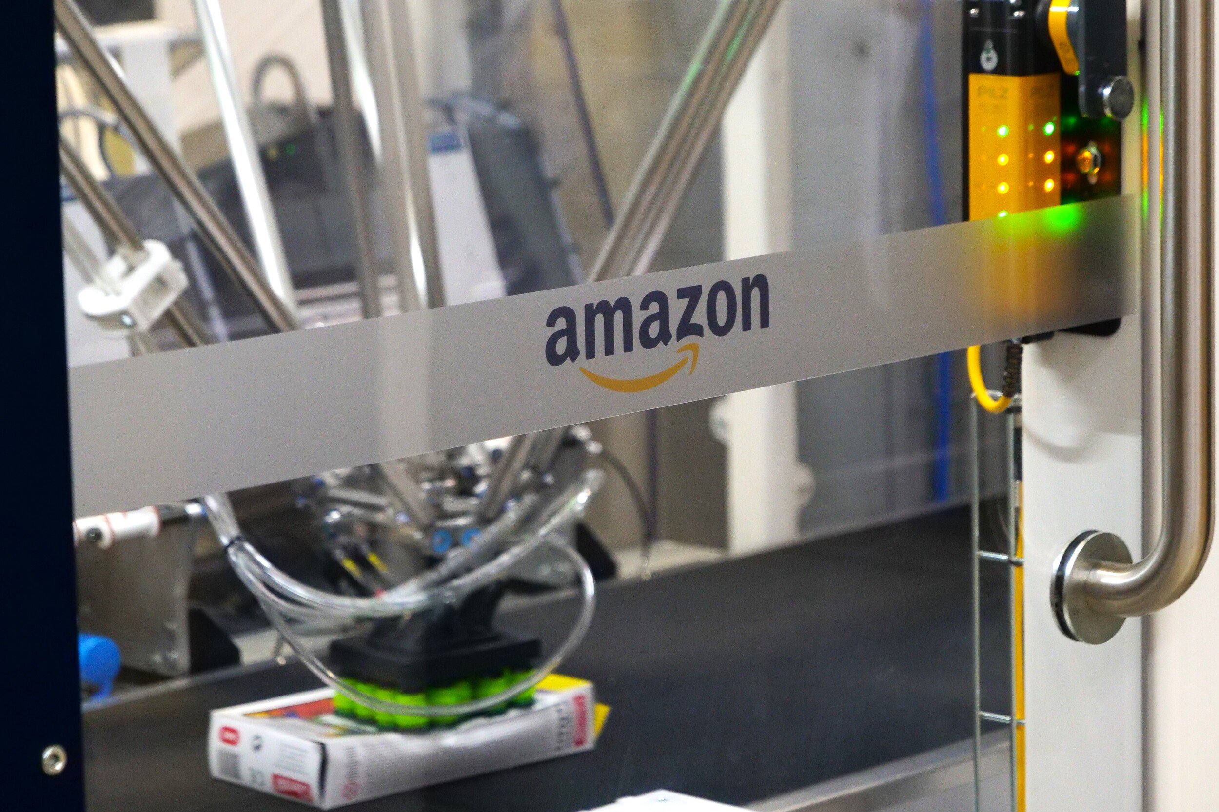 Le logo Amazon, sur une vitre qui protège la nouvelle étiqueteuse © Alexandre Boero / Clubic