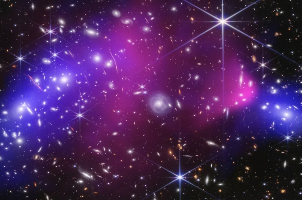 Cette image de la NASA montre des amas de galaxies massifs précédemment capturés par le télescope spatial James Webb et l’observatoire à rayons X Chandra de la NASA, avec des zones de matière noire potentielle, en bleu - ©NASA / Associated Press