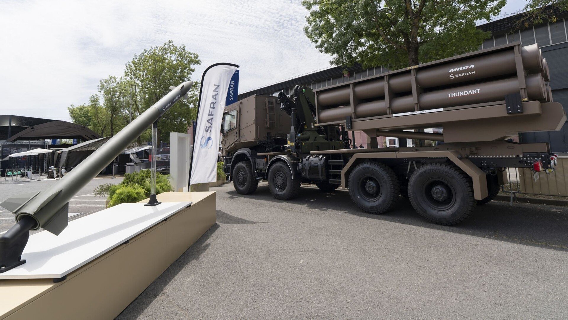 Le lanceur Thundart de Safran et MBDA, monté sur un camion Scania 8x8, exposé aux côtés d'une roquette lors d'un salon de défense. © Safran / MBDA