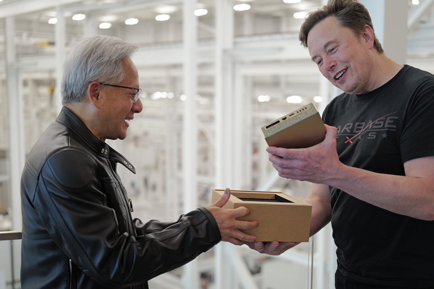 Jensen Huang en train de donner le DGX Spark à Elon Musk. ©NVIDIA