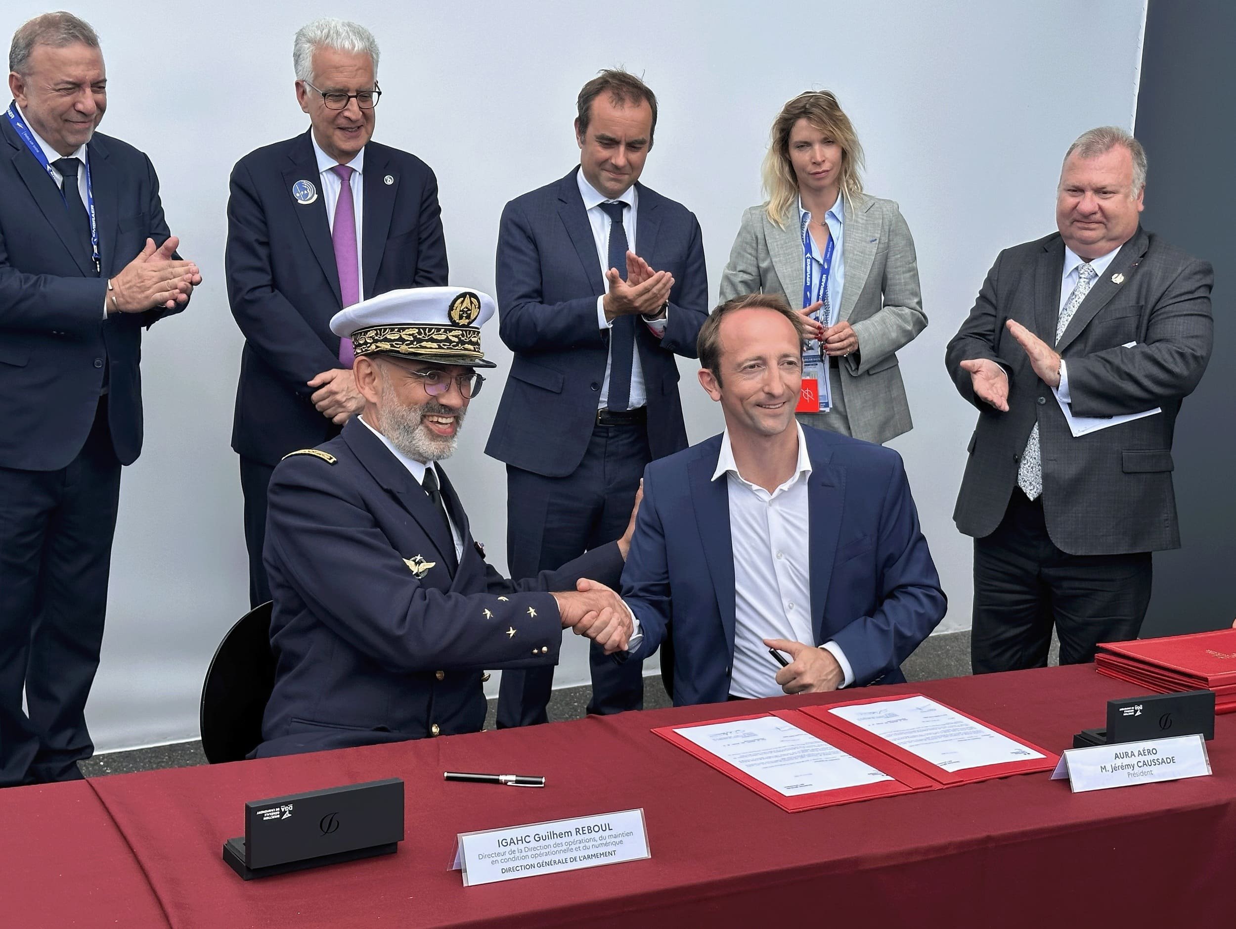 Guilhem Reboul, directeur de la Direction des opérations, du maintien en condition opérationnelle et du numérique pour la DGA, et Jérémy Caussade, président d'Aura Aero, en présence de Sébastien Lecornu, ministre des Armées, et Emmanuel Chiva, Délégué général pour l'Armement.© Aura Aero