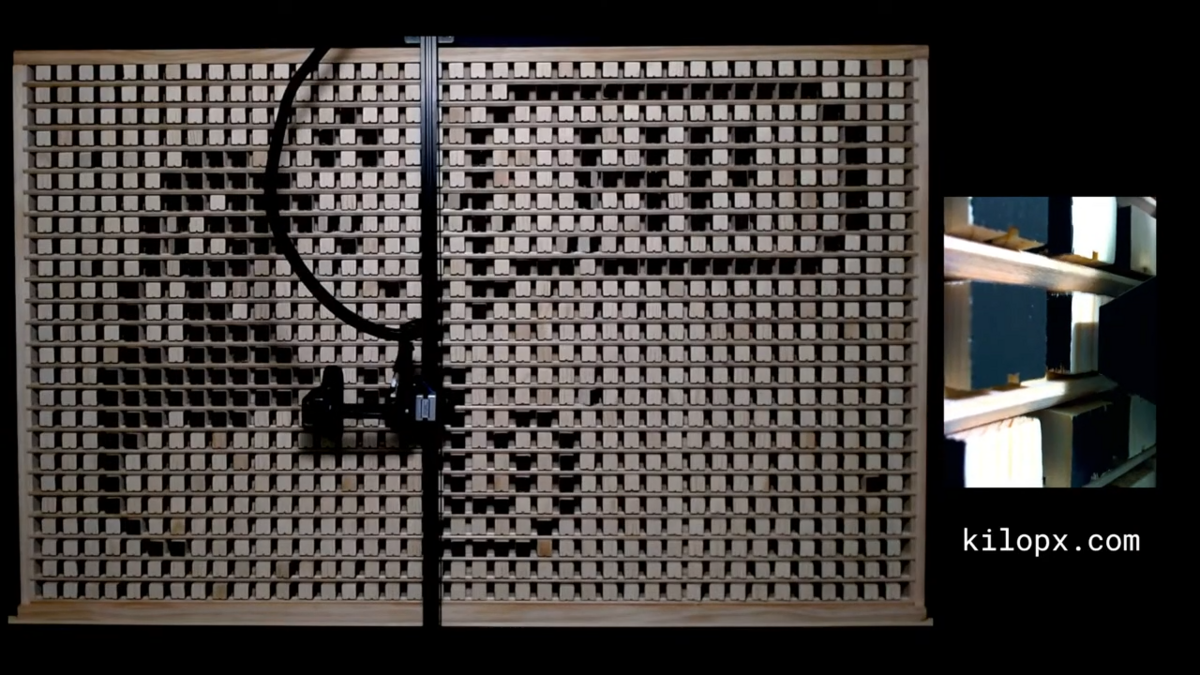 Le bras robotisé de type CNC en train de "pousser" un pixel pour le faire pivoter. C'est ce mécanisme qui dessine lentement les images soumises par les internautes. © Ben Holmen