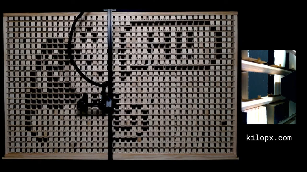 Le bras robotisé de type CNC en train de "pousser" un pixel pour le faire pivoter. C'est ce mécanisme qui dessine lentement les images soumises par les internautes. © Ben Holmen