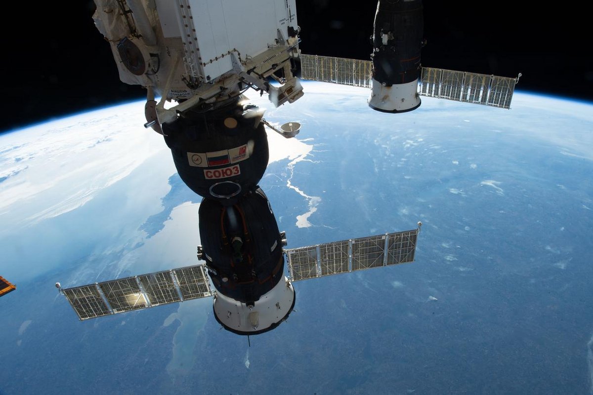 La capsule Soyouz MS-09, vue en octobre 2018 amarrée sur l'ISS. Le module orbital est la partie avec les drapeaux. Crédits NASA