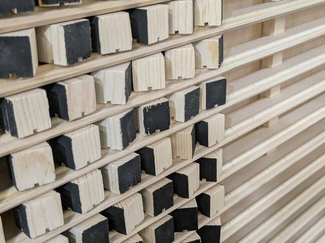 Le Kilopixel en action, affichant une image pixelisée. Chaque cube de bois est tourné individuellement par un bras robotisé pour composer le visuel. © Ben Holmen