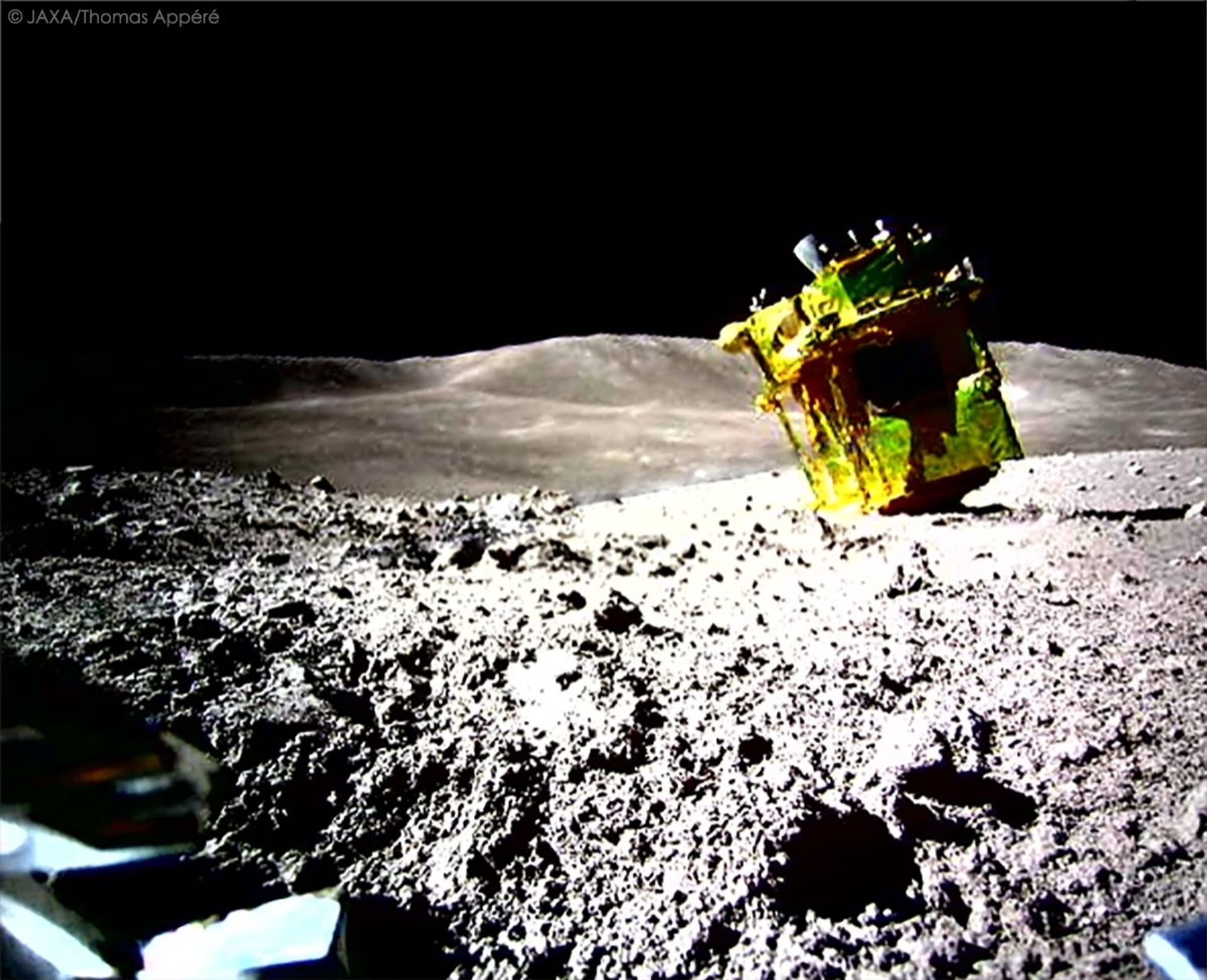 L'extraordinaire image de l'atterrisseur SLIM "la tête en bas" sur le sol lunaire, photographié par un petit robot-jouet éjecté au moment de son arrivée © JAXA / T. Appere