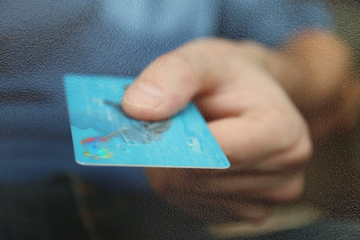 Une personne tient sa carte bancaire d'une main, et le smartphone d'une autre © joyotejo / Shutterstock