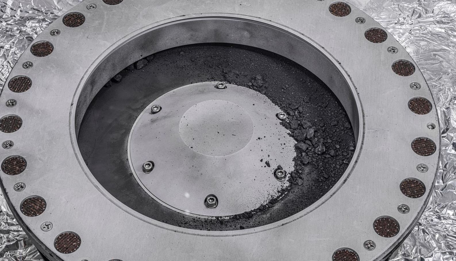 Voici à quoi ressemble le collecteur une fois ouvert. Mais gare, ce ne sont que de premiers échantillons : il y en a beaucoup plus qui ne sont pas visibles pour l'instant. © NASA