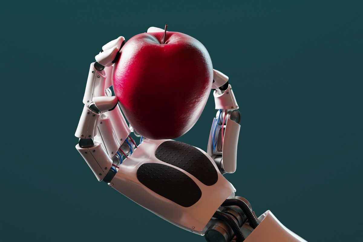 Un bras robotisé tient une pomme dans sa main. © Dabarti CGI / Shutterstock