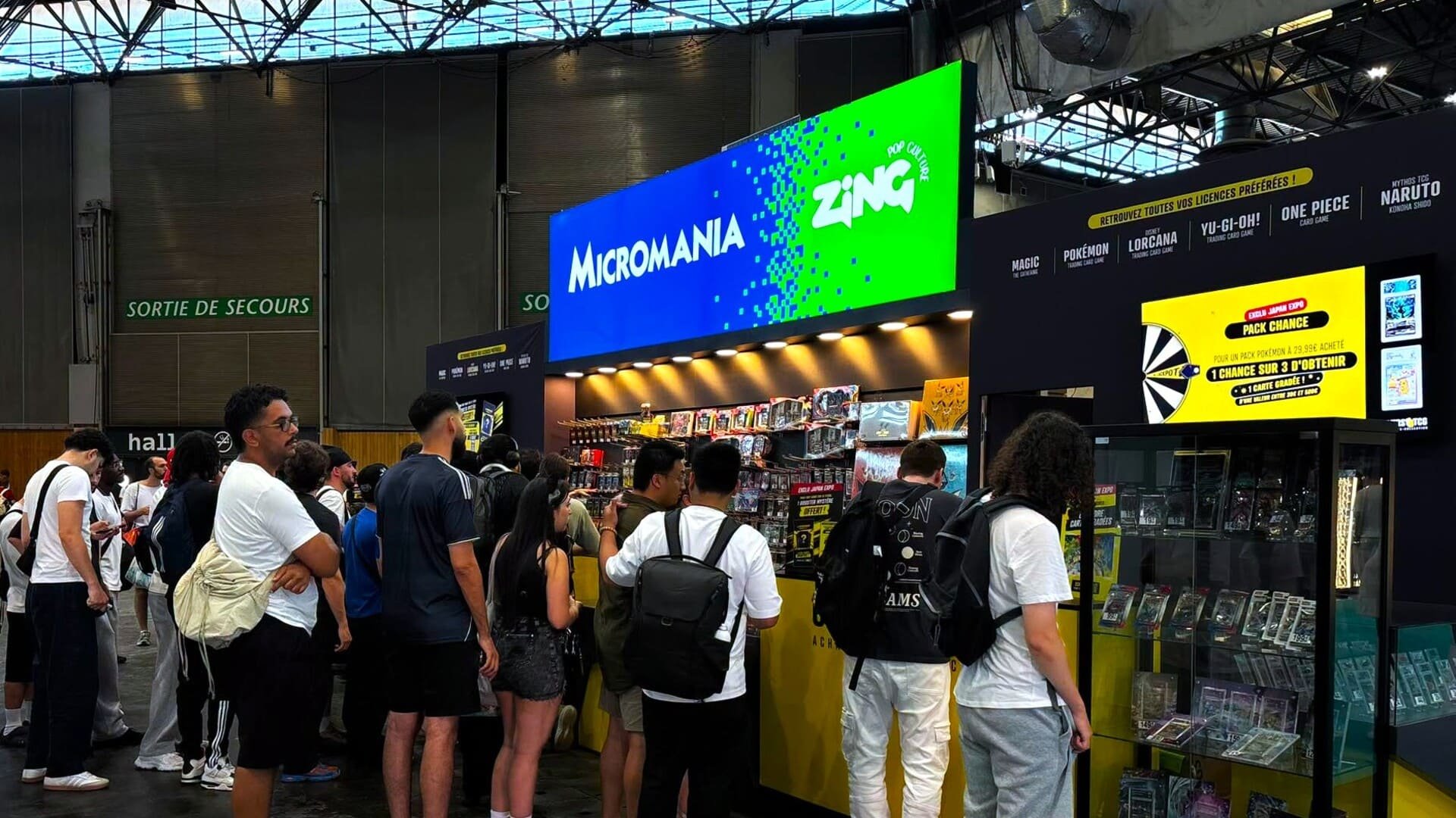 Le stand Micromania-Zing à la Japan Expo, où l'enseigne propose cartes à collectionner (Pokémon, Magic, One Piece, Naruto) et objets de collection. Un avant-goût de la stratégie affichée par les nouveaux repreneurs : miser sur les cartes et les produits dérivés. © Micromania-Zing