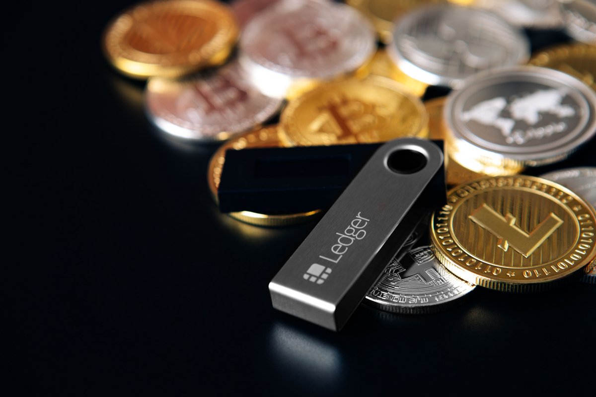 Un portefeuille crypto Ledger posé sur des pièces estampillées Bitcoin © Shutterstock