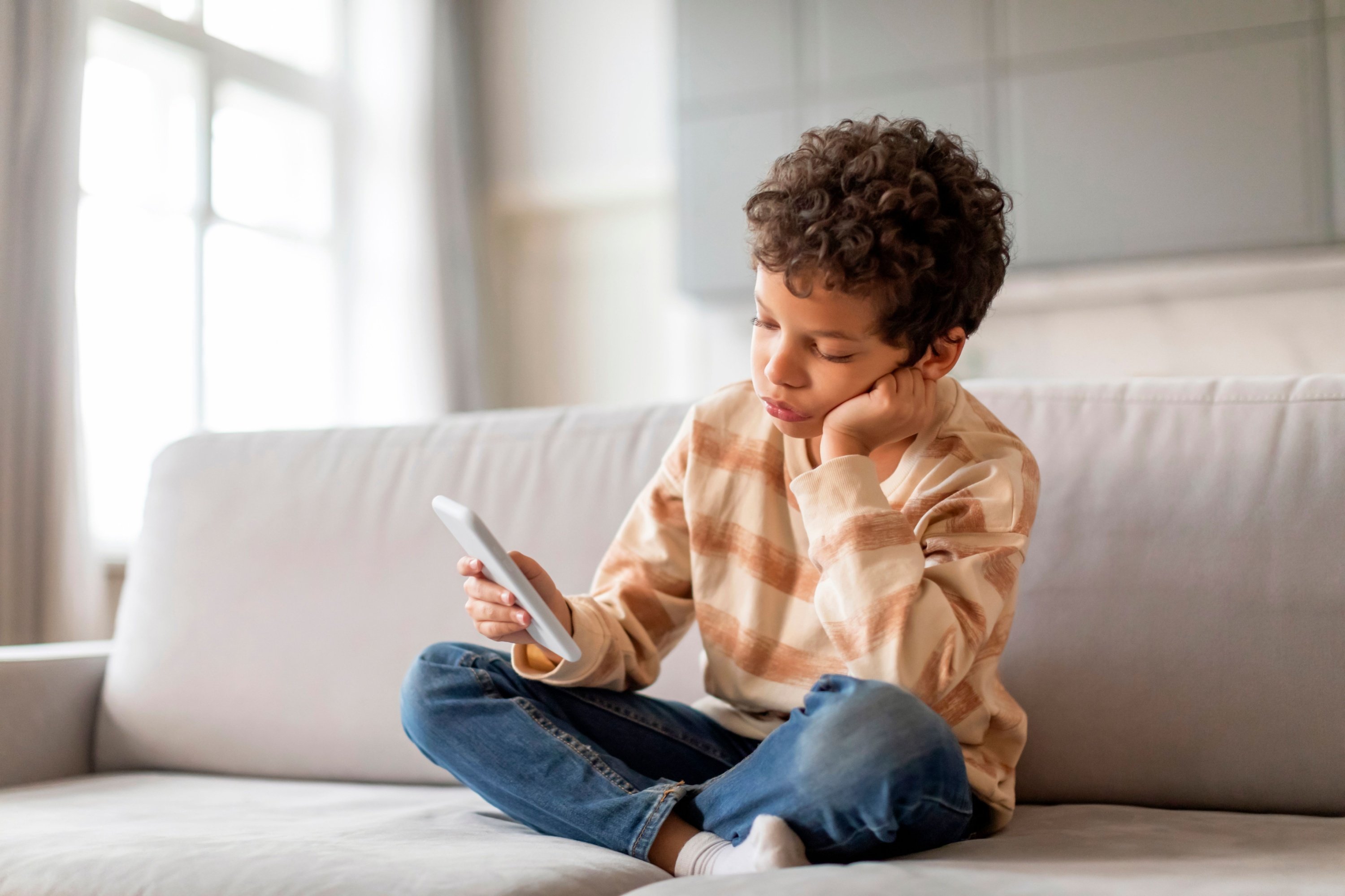 Un enfant utilise un smartphone © Shutterstock.com