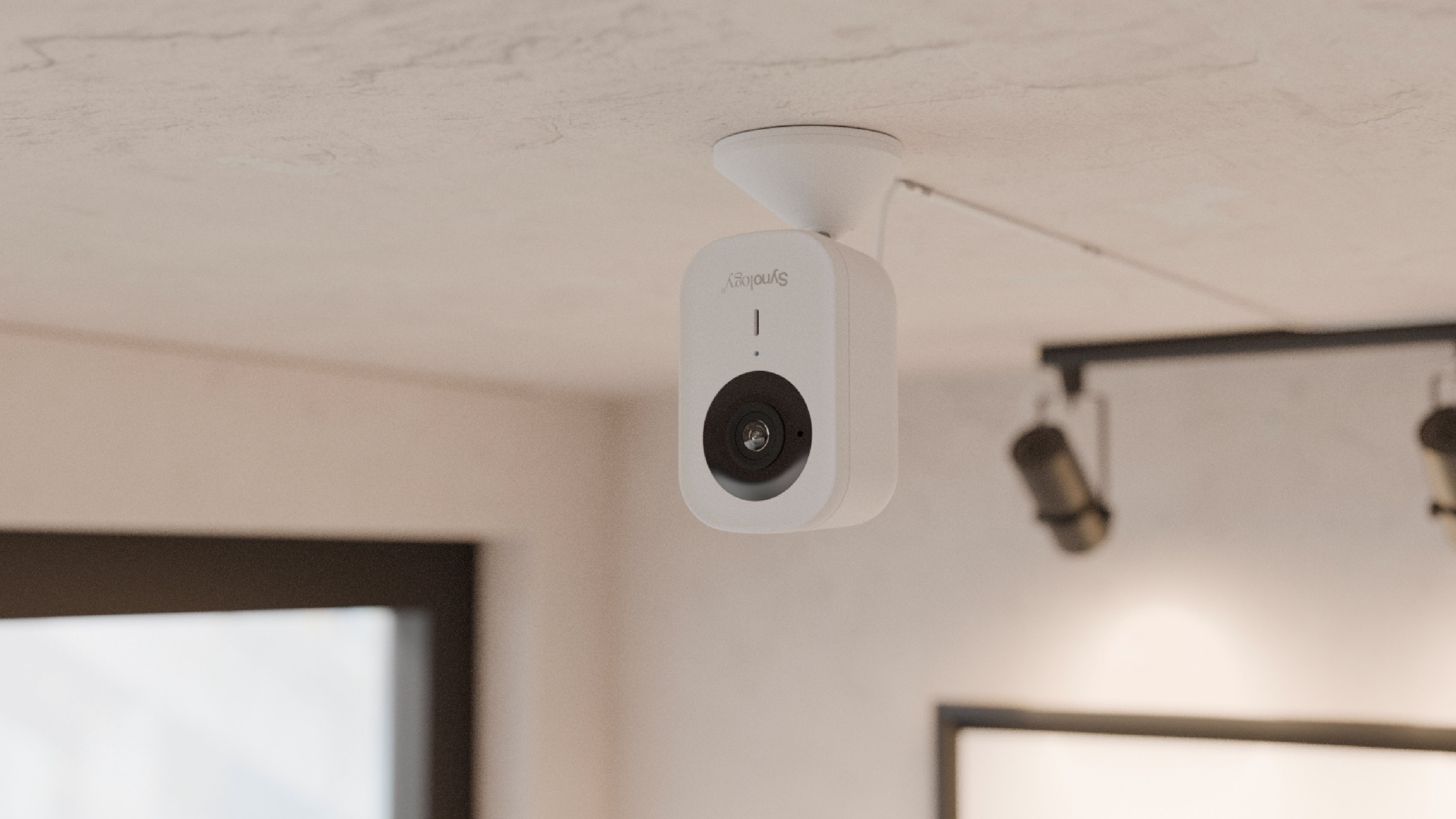 Même fixée au plafond, la CC400W garde un look sympathique de webcam à l'ancienne. ©Synology