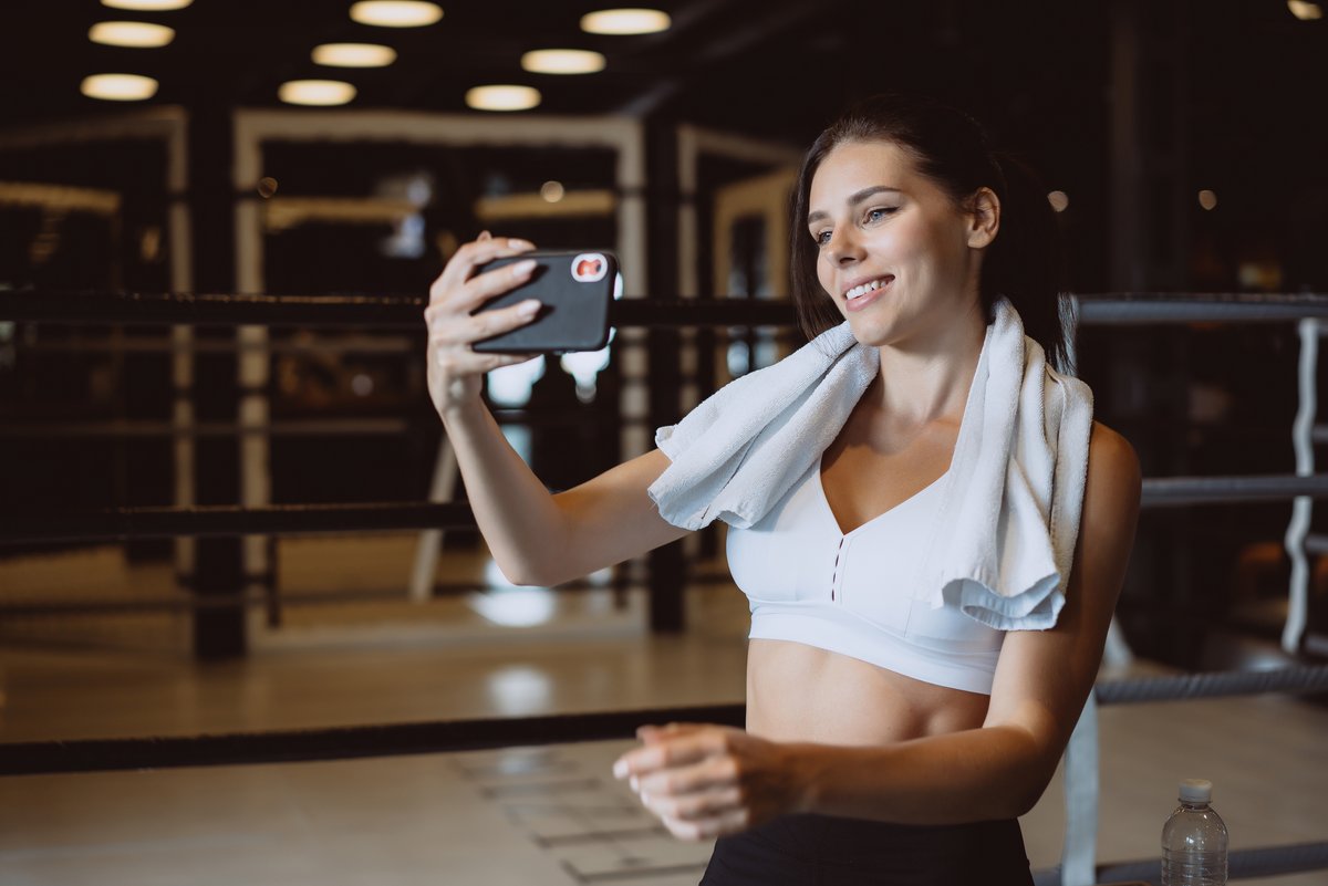 Une femme se prenant en photo, après sa séance de sport © Hrecheniuk Oleksii / Shutterstock