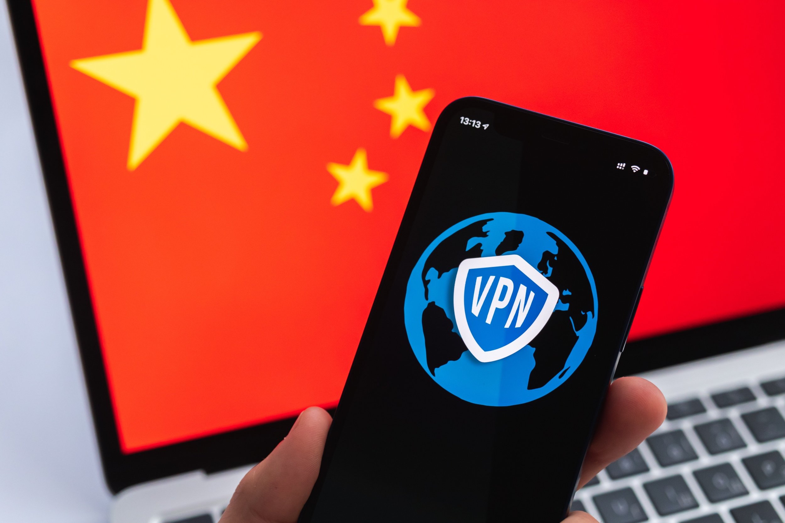Un VPN s'affiche sur un smartphone, devant un ordinateur aux couleurs de la Chine © Shutterstock