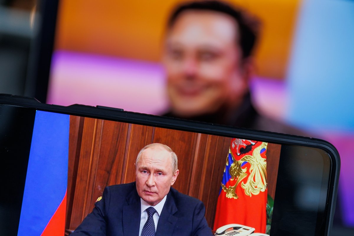 Vladimir Poutine apparaît sur un écran, avec le visage d'Elon Musk en arrière-fond © Shutterstock