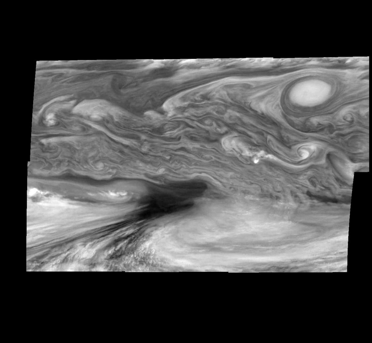 Les nuages de la zone équatoriale de Jupiter en 1998, avec une &quot;tempête chaude&quot; (qui apparaît en noir). Crédits NASA/JPL-Caltech