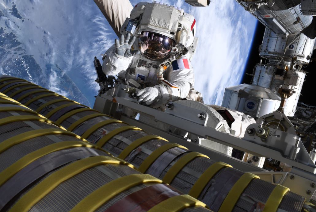 Thomas Pesquet devant un double cylindre contenant l'un des nouveaux panneaux solaires de l'ISS. Crédits ESA/T. Pesquet