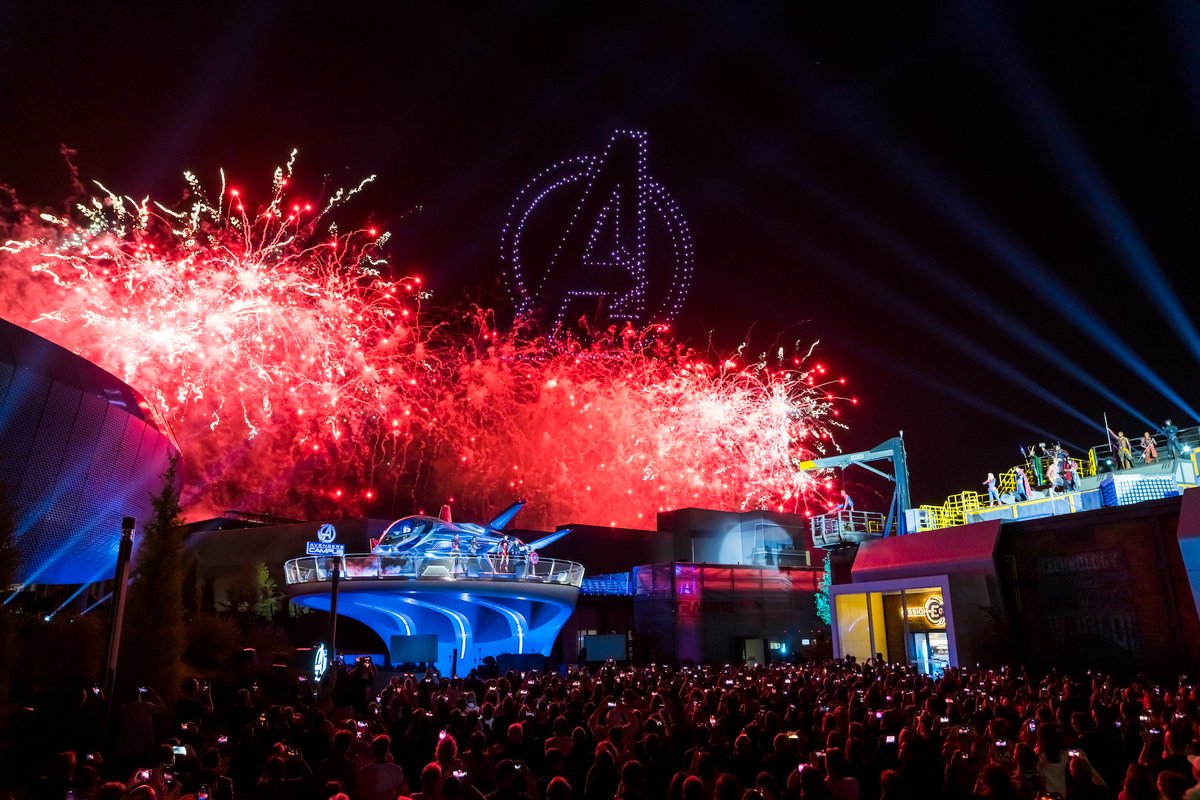 L'Avengers Campus de Disneyland Paris, illuminé avec, au premier plan, le Quinjet, et au fond, des centaines de drones qui reproduisent le logo des Avengers (© Disneyland Paris/Marvel)