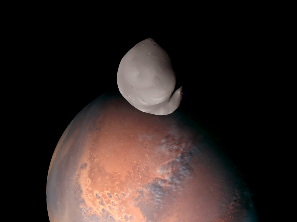 Poésie spatiale, la toute petite lune Deimos passe devant Mars et ses nuages du matin © Hope Mars Mission / MBRSC