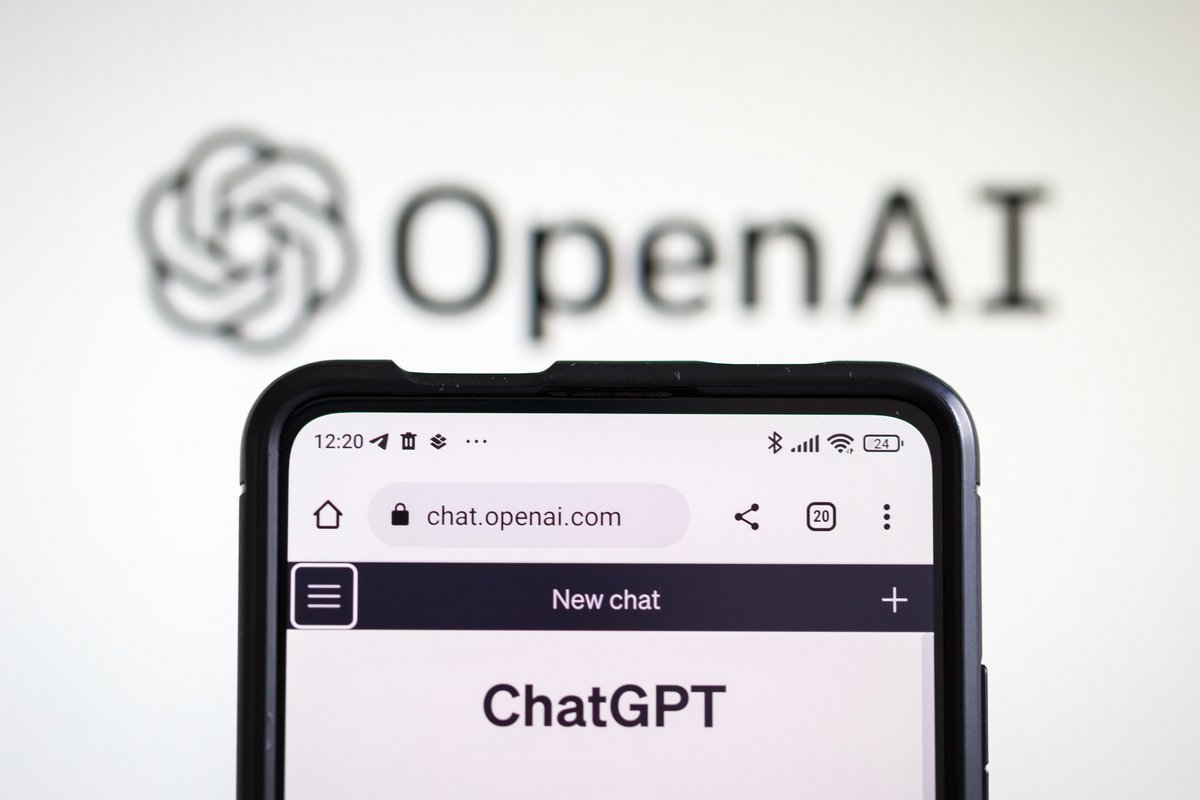 Un smartphone avec ChatGPT ouvert sur l'écran face au logo d'OpenAI © Markus Mainka / Shutterstock
