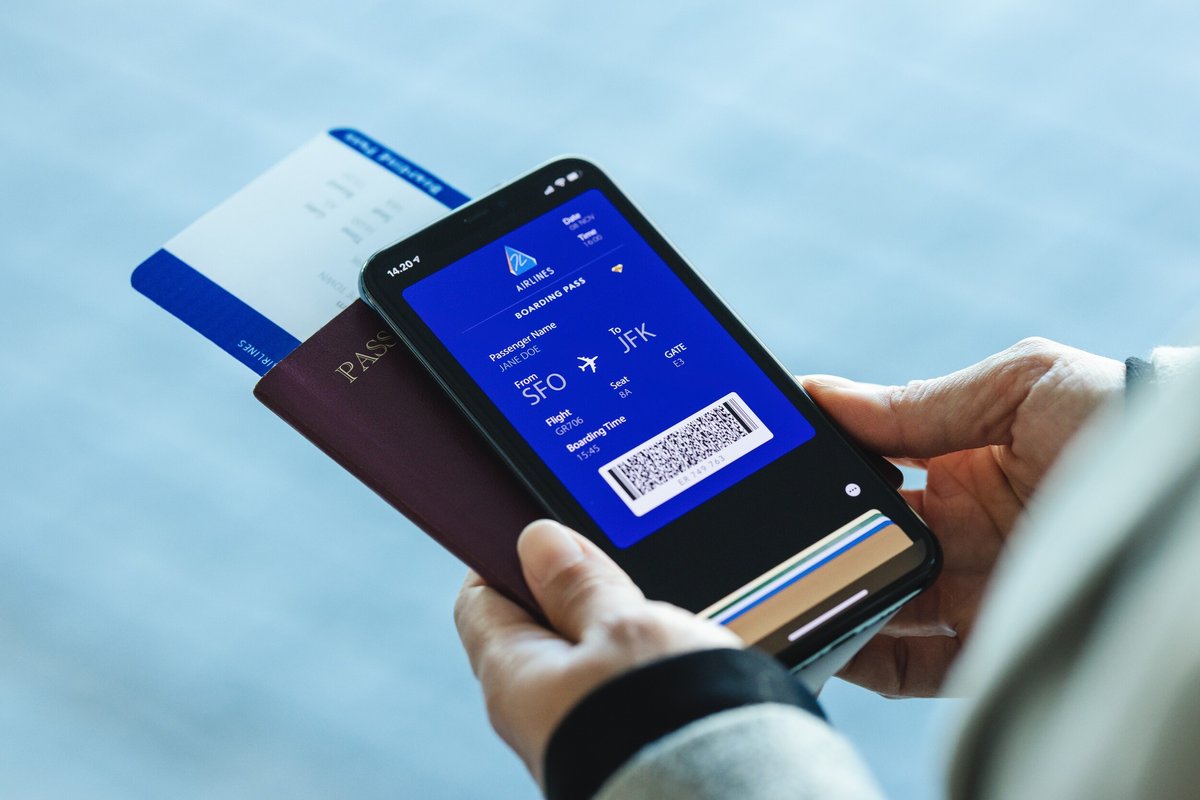 Une carte d'embarquement papier avec sa version numérique et un passeport © Jacob Lund / Shutterstock
