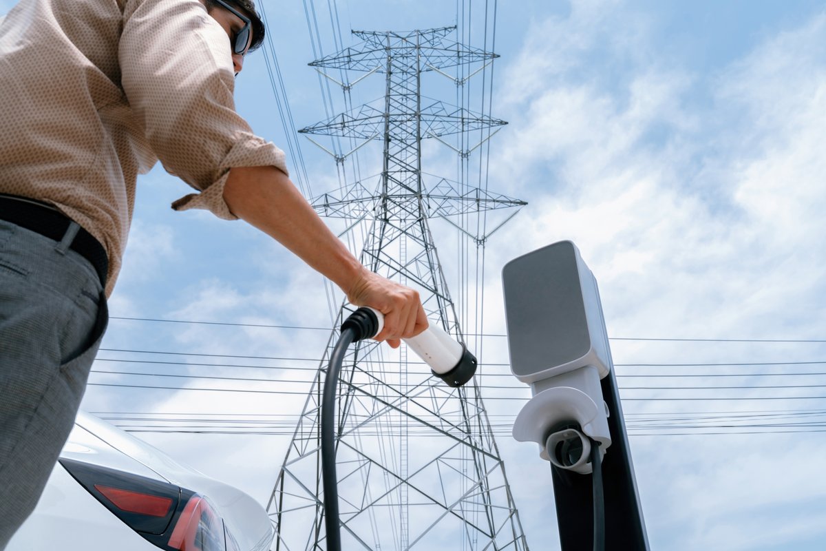Un homme recharge la batterie de sa voiture électrique © Owlie Productions / Shutterstock