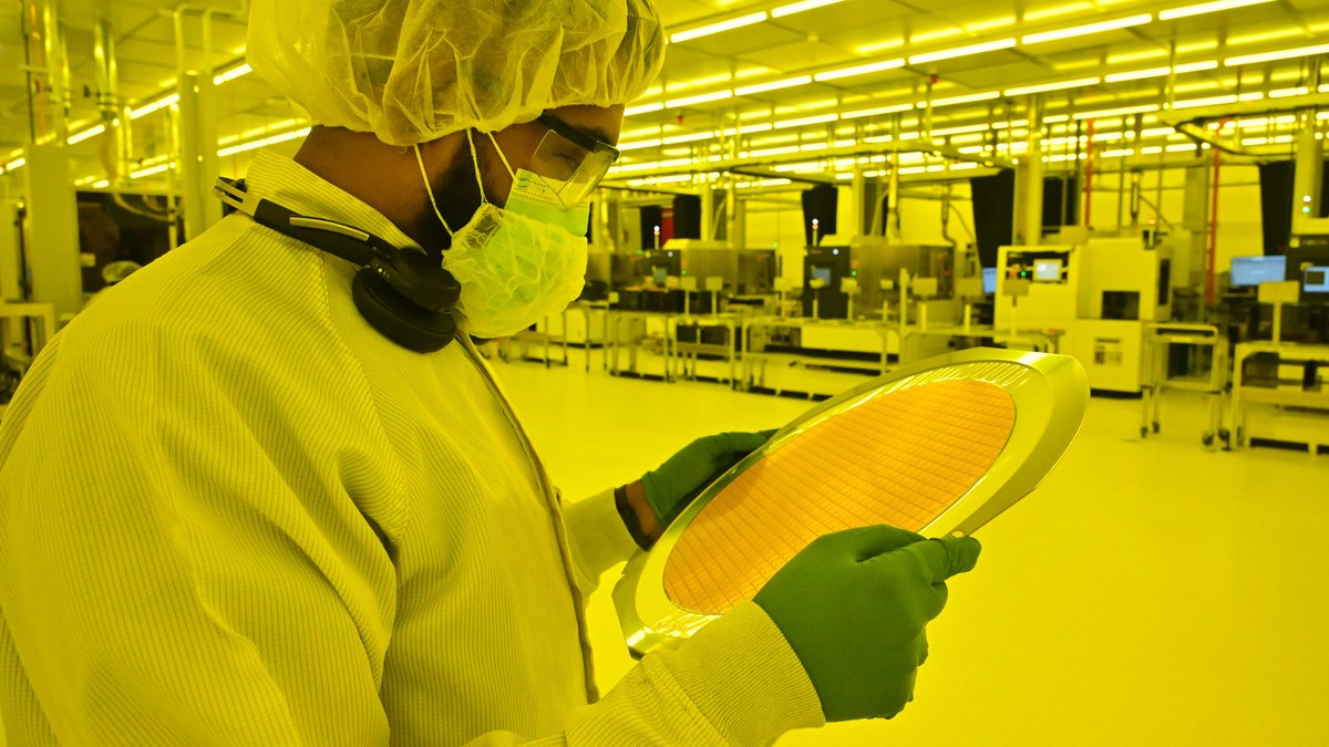 Sous la lumière ambrée (privée d&#039;UV) un employé d&#039;Intel examine un wafer à peine reçu © Intel