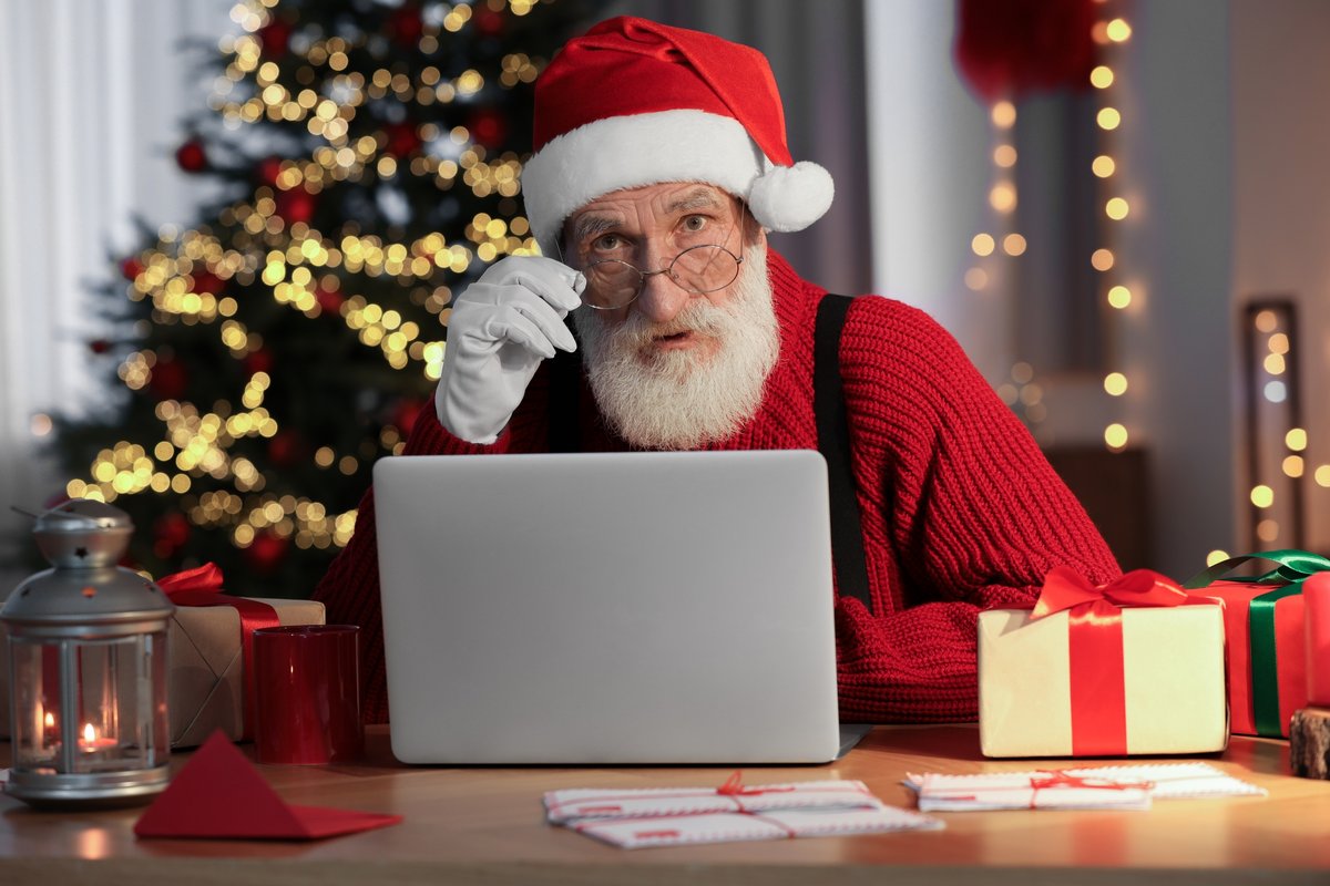Le père Noël devant un ordinateur © New Africa / Shutterstock