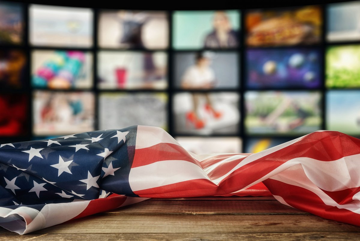 Un drapeau américain replié fait face à des écrans © Shutterstock