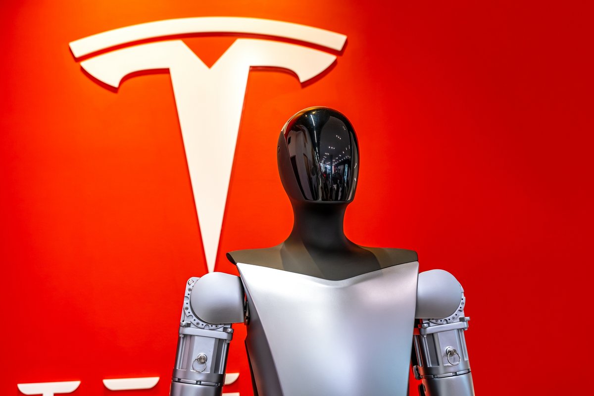 Le robot Optimus, devant le logo de Tesla © Iv-olga / Shutterstock.com