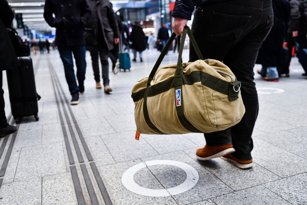 Les personnes qui portent leurs valises avant un voyage, dans une gare parisienne © Victor Velter / Shutterstock