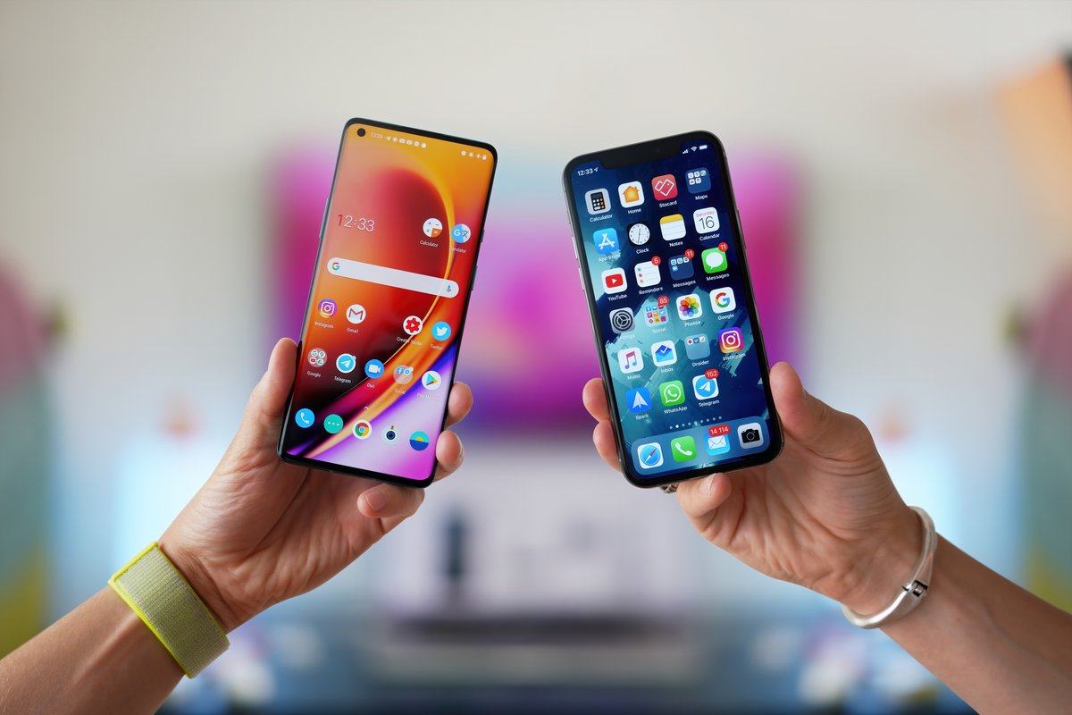 Un smartphone Android et un iPhone dans les mains d'utilisateurs © Mr.Mikla / Shutterstock