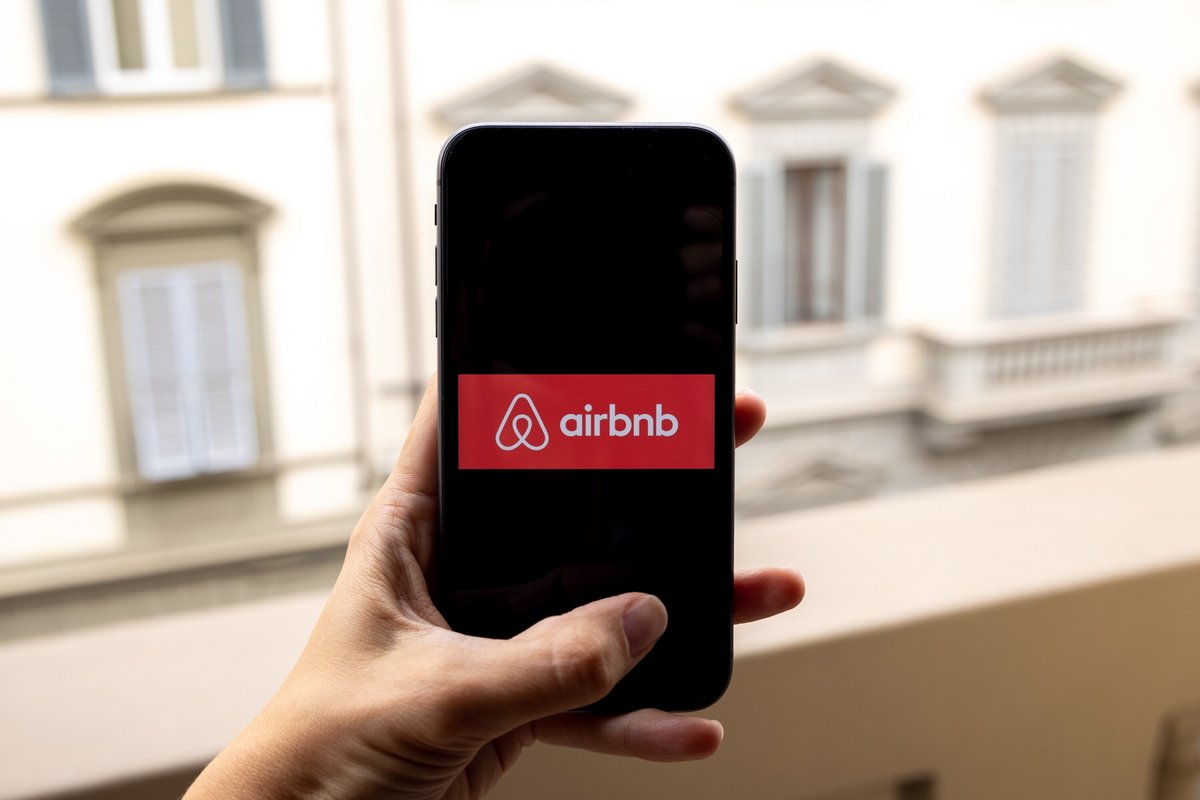 Le logo Airbnb sur smartphone, devant une fenêtre © Boumen Japet / Shutterstock