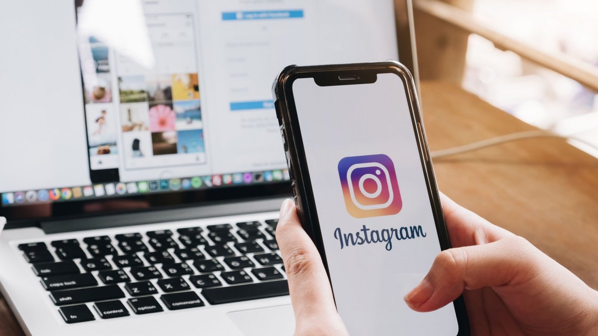 L'application Instagram est affiché sur un smartphone en premier plan, et sur un ordinateur au fond © Shutterstock